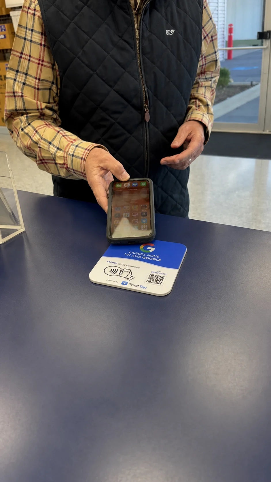 Un client utilise la plaque TrustTap sur un comptoir