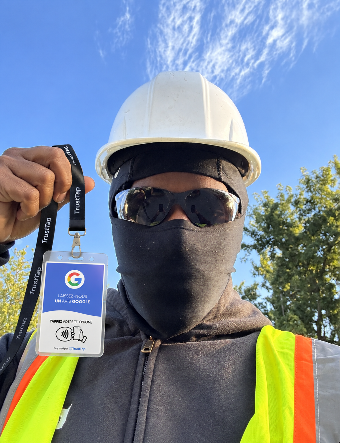 Travailleur en casque blanc présentant son badge TrustTap